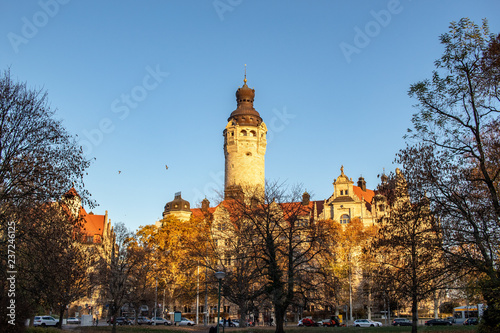 Wonderful autumn panorama with park landscape, city skyscraper, new city hall and brightly colored trees and leaves in Leipzig
