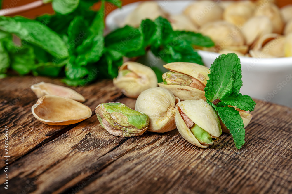 Bowl with pistachios on a wooden table. Bowl with pistachios on a wooden table.