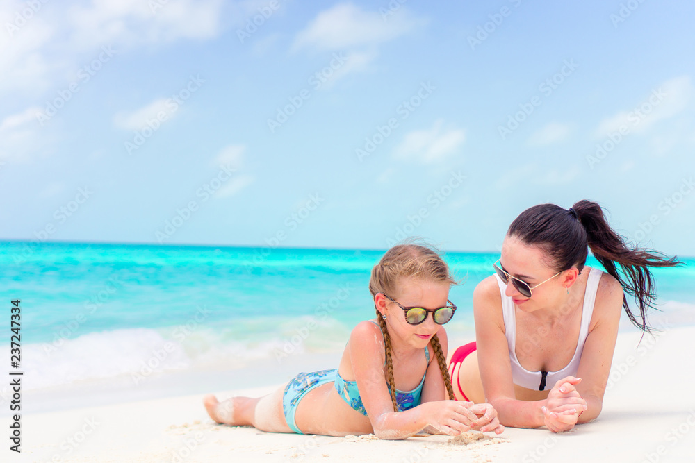 Little cute girl and young mother at tropical beach