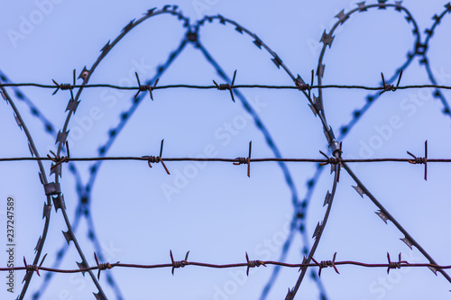 The barbed wire silhouette on the background of blue sky
