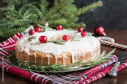 Traditional homemade Christmas cake with garnish cranberry and rosemary on decorative plate. photo