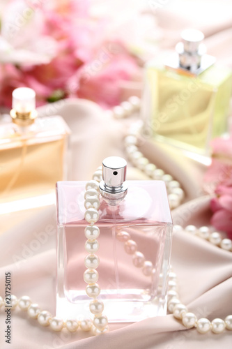 Perfume bottle with beads on satin background