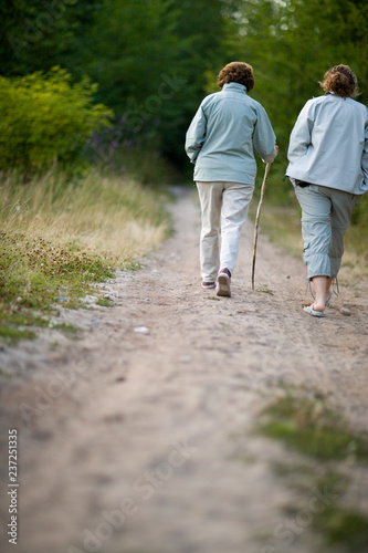 Two woman walking on a beach track.