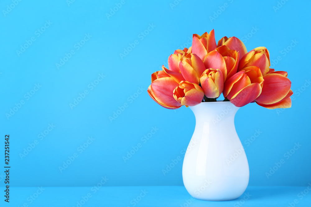 Bouquet of tulips in vase on blue background Bouquet of tulips in vase on blue background