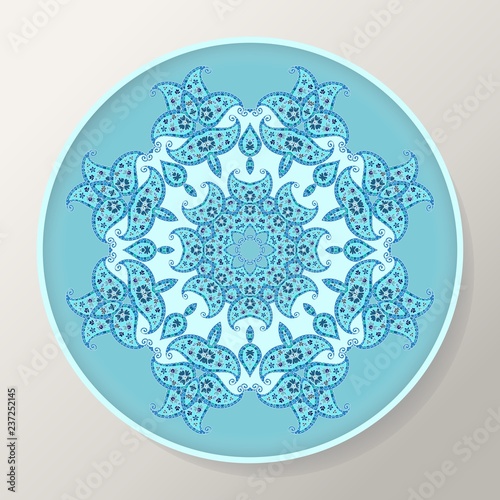 Decorative round plate with blue ornamental mandala from floral elements.