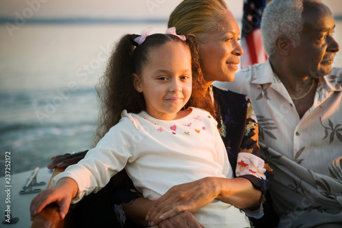 Portrait of a mature adult couple sitting with their young granddaughter while on a boat. photo