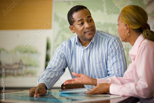 Mid-adult businessman discussing work with a mature female colleague. photo