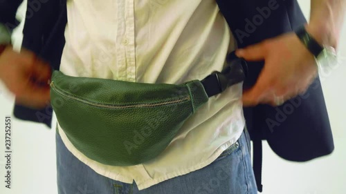 Man adjusts clothes and fanny pack before posing on photo session