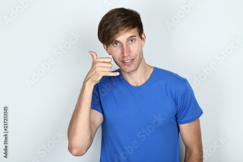 Beautiful young man in blue t-shirt on grey background