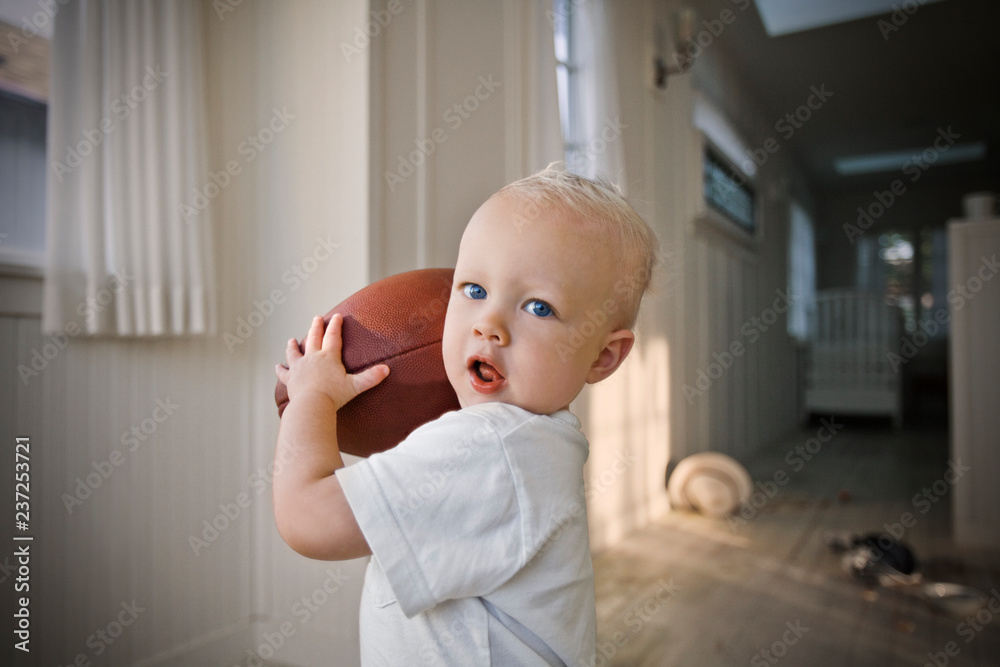 Young male toddler holding a rugby ball Young male toddler holding a rugby ball