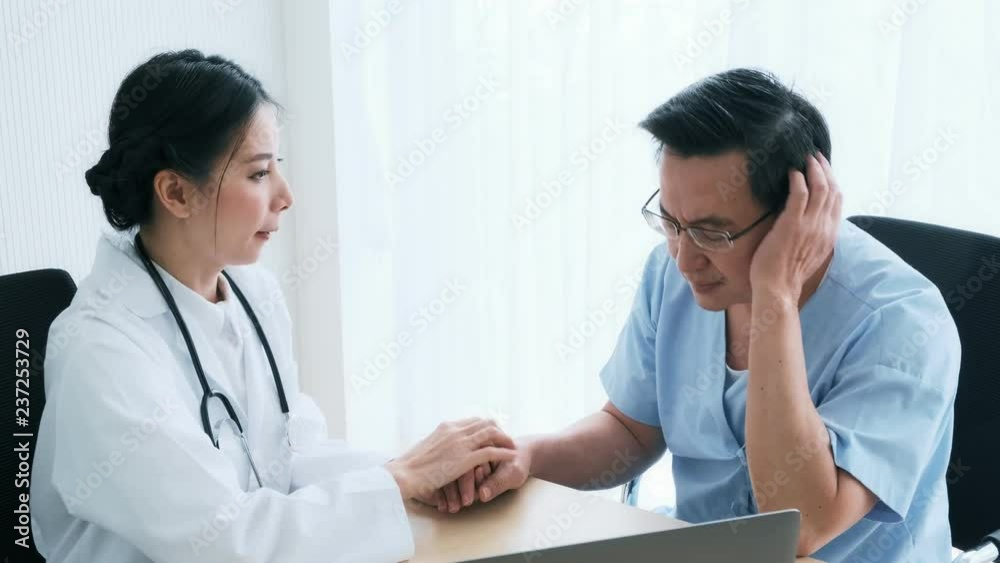 Doctor with patient. Young female medical doctor talking to a senior patient at hospital. Looking at her laptop to discuss medical examination result. Senior care medical and insurance concept. Doctor with patient. Young female medical doctor talking to a senior patient at hospital. Looking at her laptop to discuss medical examination result. Senior care medical and insurance concept.