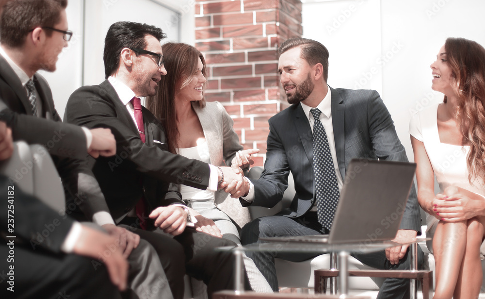 business partners shaking hands at a business meeting business partners shaking hands at a business meeting