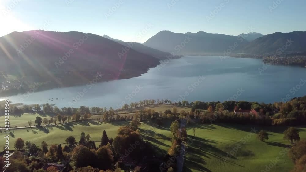 4k Panoramic drone flight from North Part of the Lake Tegernsee at sunset with fog in autumn. The lake is one of the cleanest lakes in Bavaria and is a popular tourist destination.