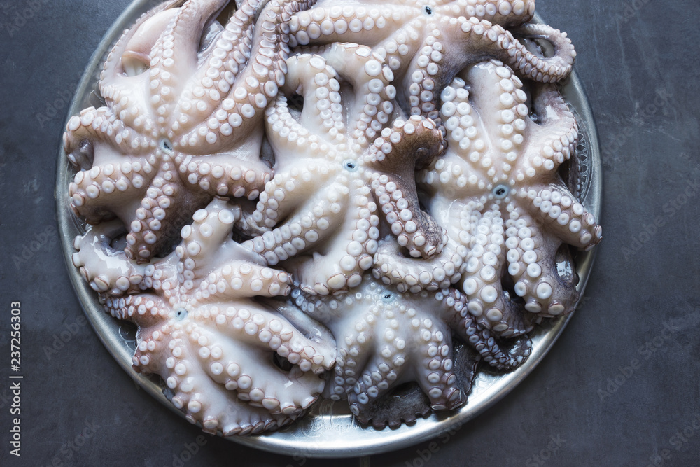 Fresh raw octopus on a large platter. Concept - healthy food