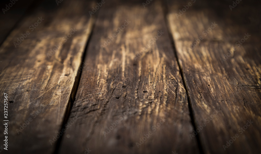 Brown wood scratched desk board texture. Selective focus. Close up. Abstract background, empty template, text space.