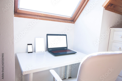 Responsive web design concept. Smartphone, tablet and laptop with blank screen on home office desk. © GENETTICA