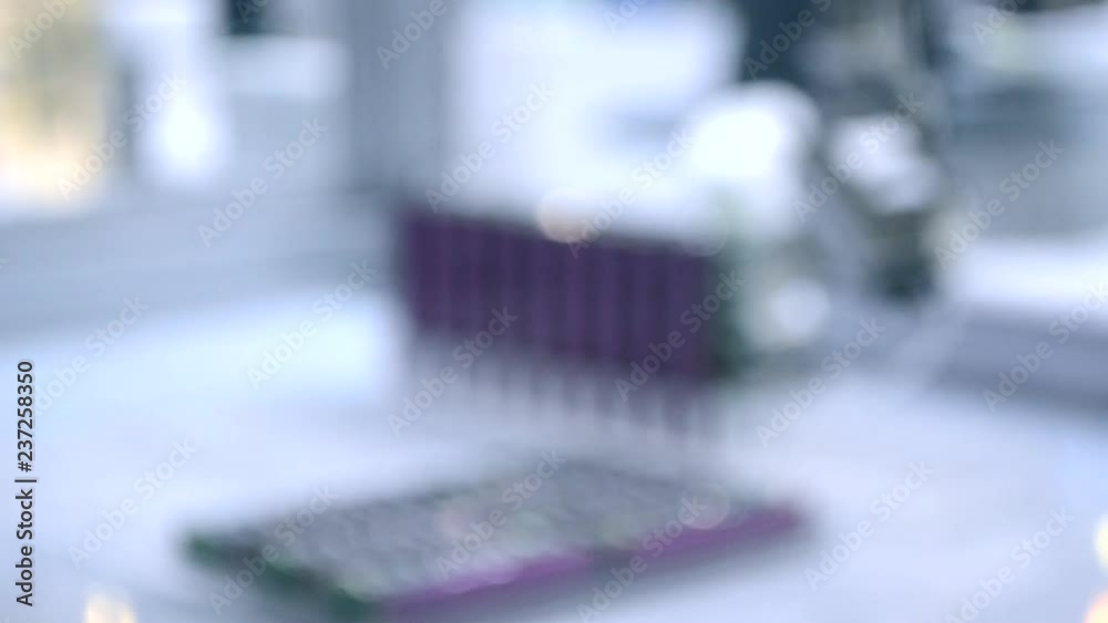 Automatic robot arm for conveyor puts flat objects with sucker on flat surface close-up. Blurred Background. White blue color. Automatic robot arm for conveyor puts flat objects with sucker on flat surface close-up. Blurred Background. White blue color.