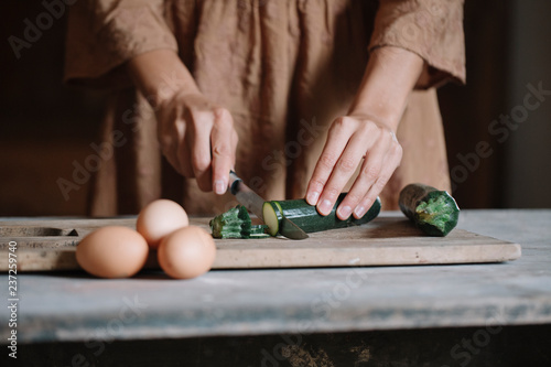 Woman slising small zucchini photo