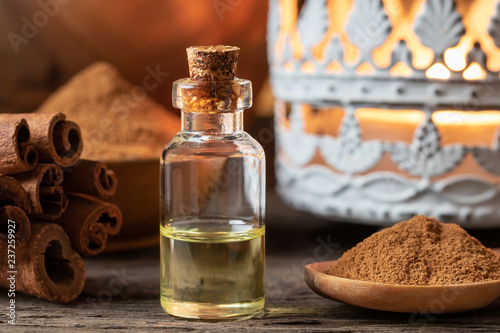 A bottle of cinnamon essential oil with cinnamon