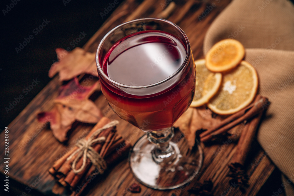 mulled red wine with spices and fruits on a wooden rustic table. Traditional hot drink at Christmas time mulled red wine with spices and fruits on a wooden rustic table. Traditional hot drink at Christmas time