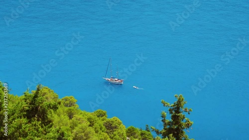 Luxury white sailing yacht in the open blue bay. Vacations in mediterenean sea. Secluded Islands in Greece. Travel adventure carefree and happiness concept. photo