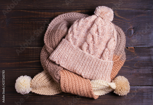 Knitted hat and scarf, winter concept. Women winter warm accessories on wooden background. Flat lay, view from above, top