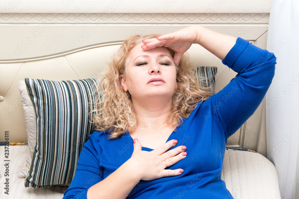 A woman feels bad because of menopause. Hot flashes, sweating