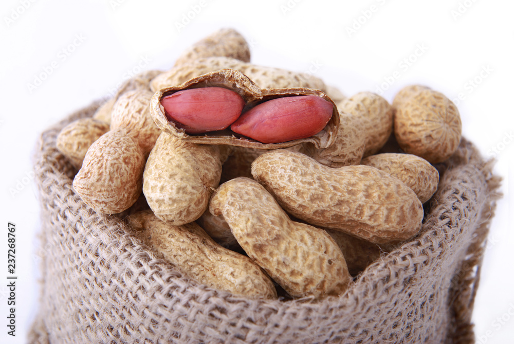 Peanuts in a peel in a bag on a white background. Peanuts in a peel in a bag on a white background.