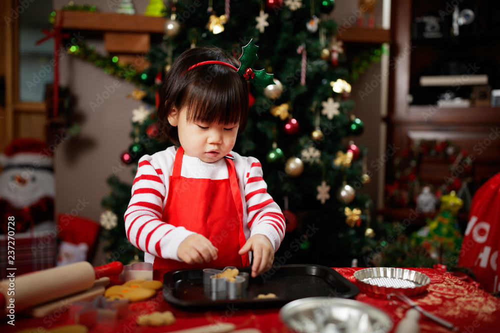 toddler baby girl preparing christmas party in fornt of christmas tree toddler baby girl preparing christmas party in fornt of christmas tree