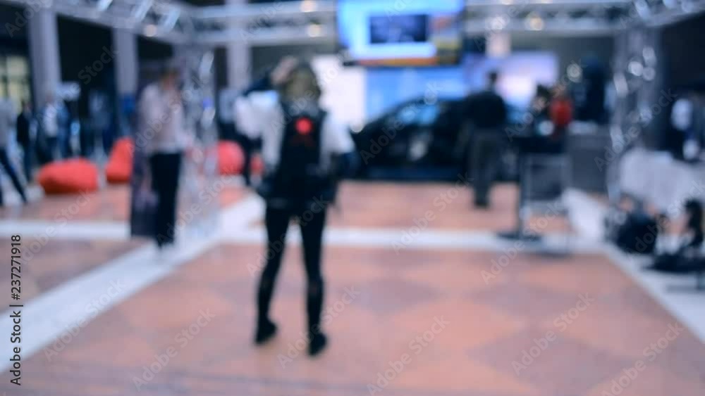 Blurred View of People. People in a large modern hall. Blurred Background. Blue red color. Blurred View of People. People in a large modern hall. Blurred Background. Blue red color.