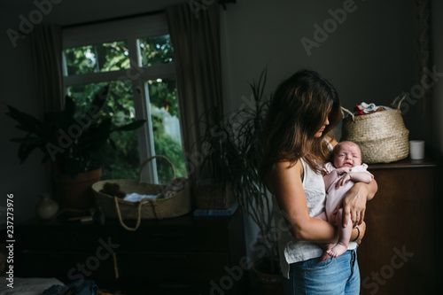 Young mom consoling newborn baby photo