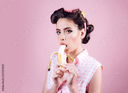 pretty girl in vintage style. pinup girl with fashion hair. banana dieting. pin up woman with trendy makeup. retro woman eating banana, copy space. Taking order on fruits