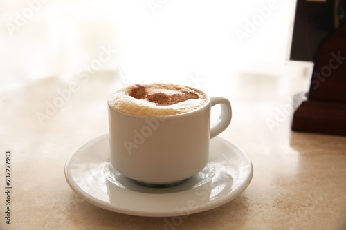 cup of coffee with whipped cream on light background