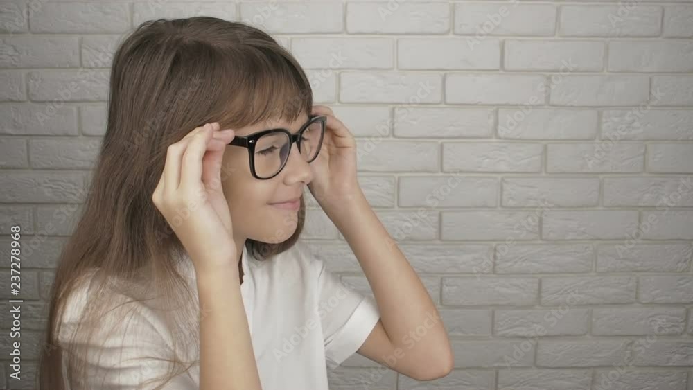 The child puts on glasses. Cute little girl with glasses for vision. The child puts on glasses. Cute little girl with glasses for vision.
