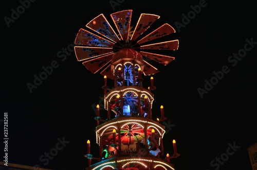 weinachspyramide (Christmas pyramid) in Christmas market Europe with monument in background