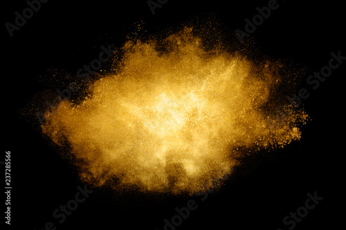 Golden color Explosion. Glitter dust particles isolated on black background