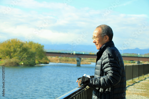 川を眺めるシニア男性 © apple713