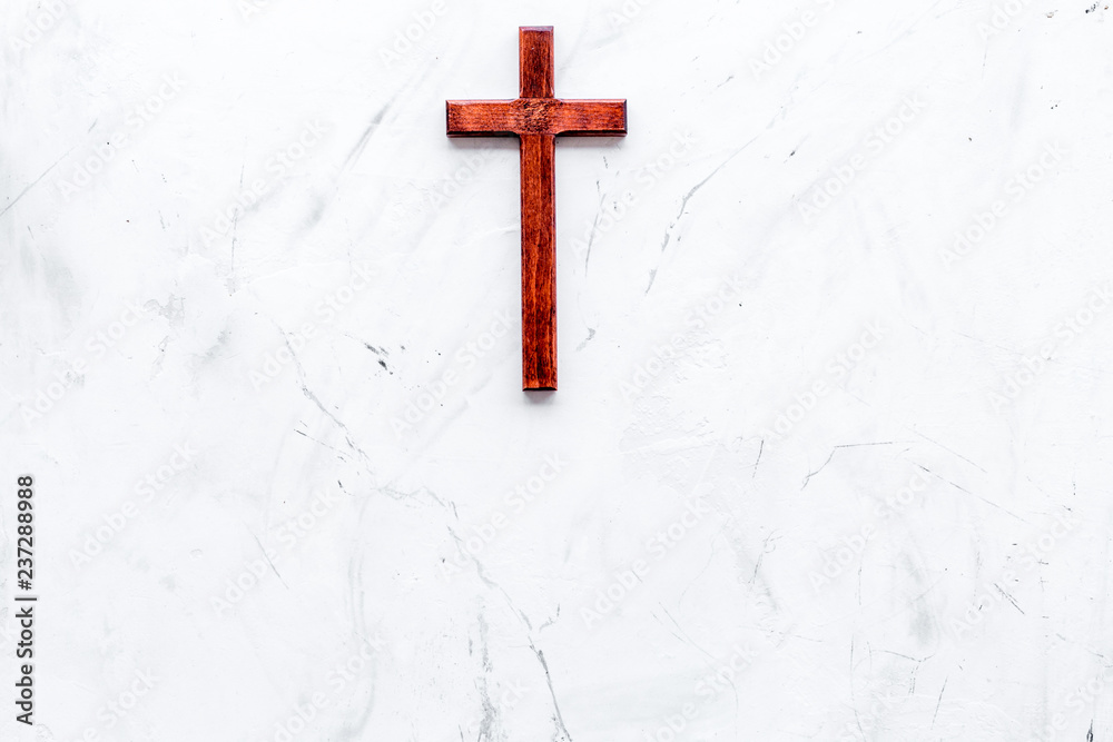 Funeral concept. Wooden cross on white stone background top view copy space