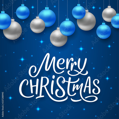 Merry Christmas seasons greetings text on blue background with sparkles and colorful hanging balls. Vector illustration for holidays with lettering