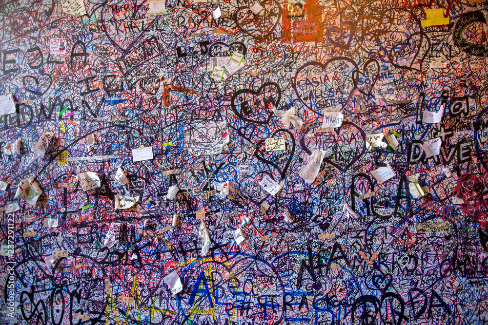 Obraz premium Graffiti on the brick vole Juliet's house in Verona. Wall covered with love messages, Juliet's House, Verona, Italy.