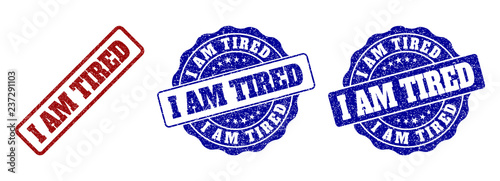 I AM TIRED scratched stamp seals in red and blue colors. Vector I AM TIRED labels with scratced surface. Graphic elements are rounded rectangles, rosettes, circles and text labels.