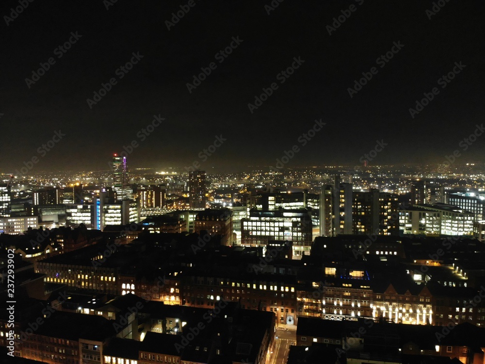 Aerial night time photo taken above the Leeds City Center at Christmas Time showing the Leeds Town Hall and buildings and roads around West Yorkshire.