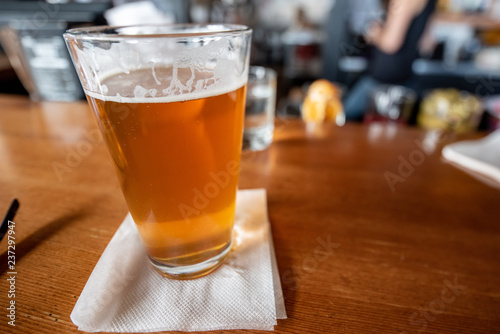 a pint of beer sits at a bar