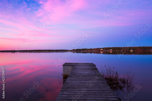 Fototapeta Naklejka Na Ścianę i Meble -  A Pink sunrise and reflections on a still lake