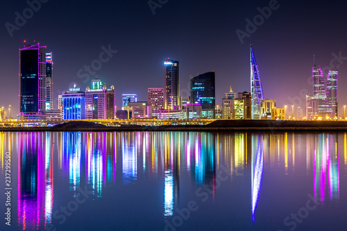 The skyline of Manama, capital of Bahrain with the World trade Center building at night and water reflection photo