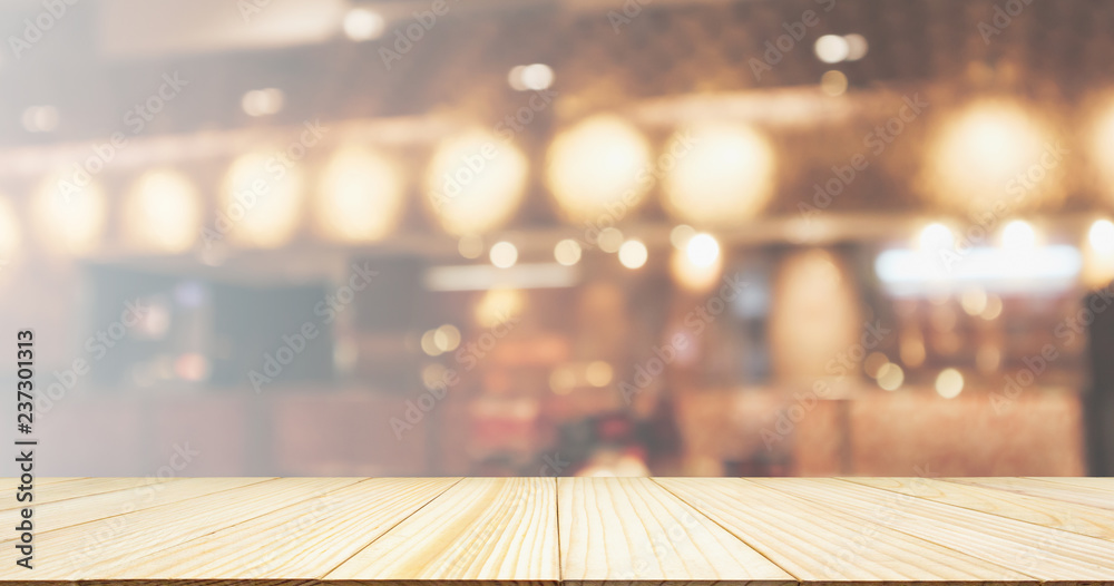 Wood table top with Restaurant cafe or coffee shop interior with people abstract defocused blur background