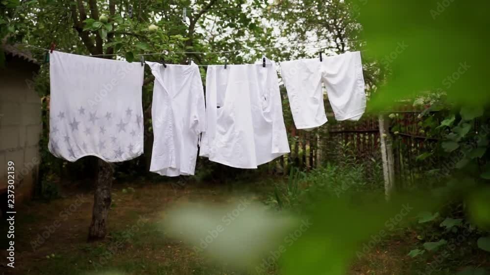 Linen is dried on the street. Detergent. Bleached clothes. Laundry hanging on a tree.