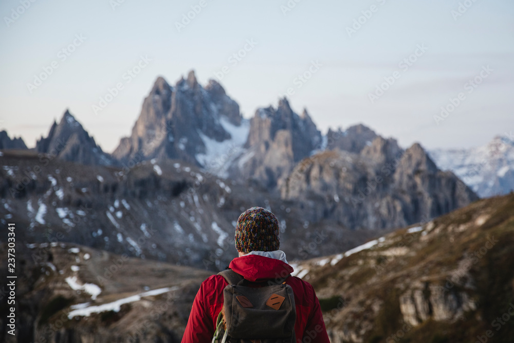 Hiker observing the rocky landscape of Dolomites Hiker observing the rocky landscape of Dolomites