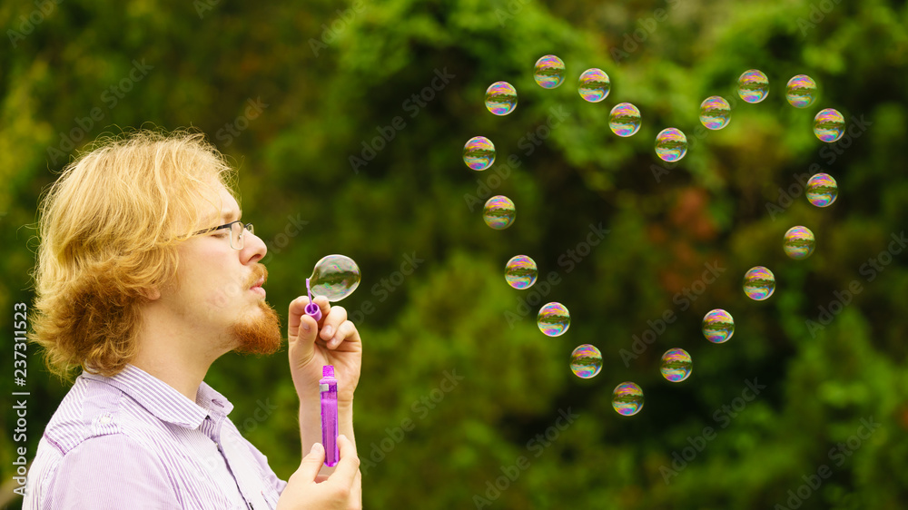 Man blowing soap bubbles outdoor