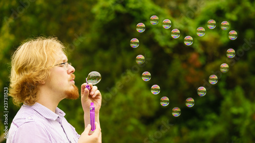 Man blowing soap bubbles outdoor